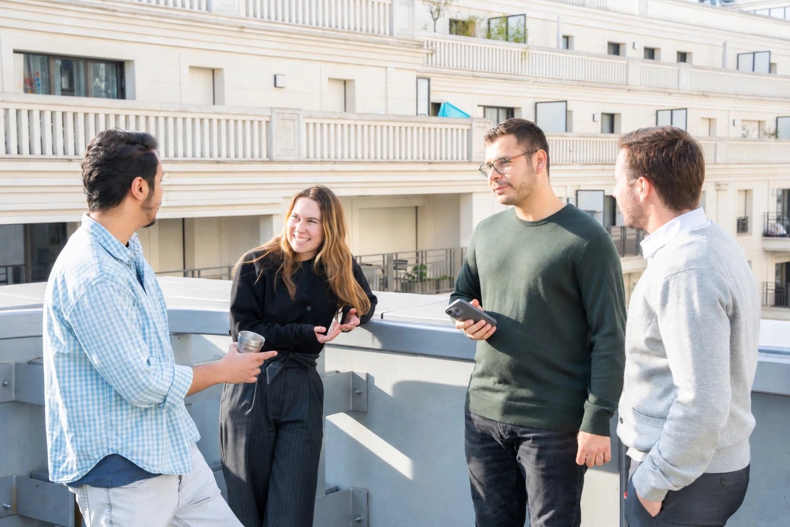 Quatre membres de l’équipe AVANGARDISM réunis sur la terrasse.